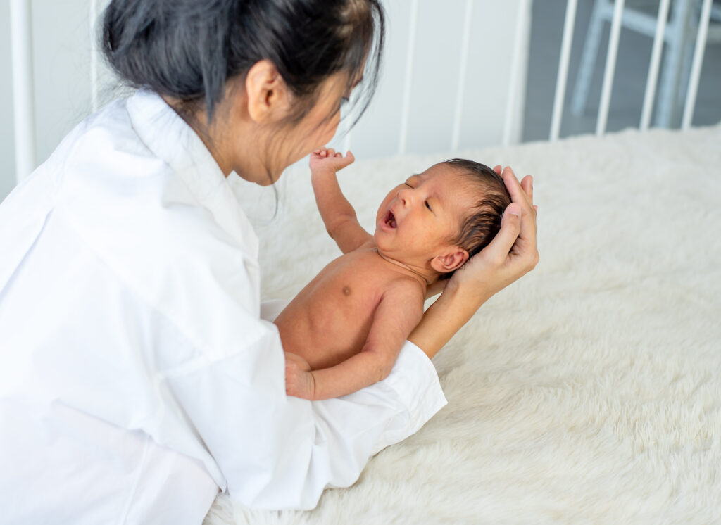 asian mother hold her little newborn baby from bed 2025 03 05 05 36 11 utc